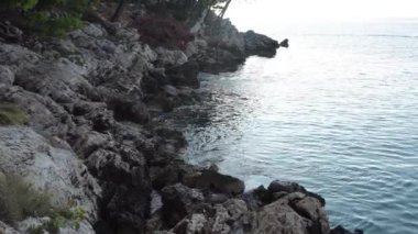 Kayalık sahilde yumuşak dalgalar sörf yapar