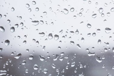 Şehir planına sahip pencere camlarına yağmur damlaları yağar.