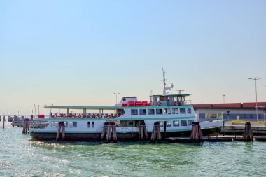 Turistler için tekne Venedik gölündeki rıhtımda duruyor.