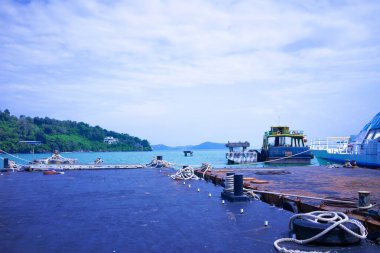 Denizin ortasında bir ada ve kıyıya demirlemiş eski bir gemi.