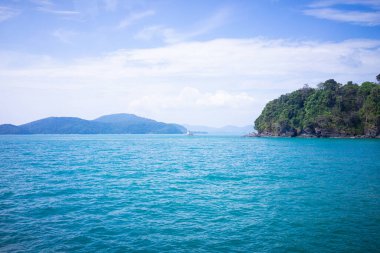 Denizin ortasında bir ada ve bir deniz feneri.