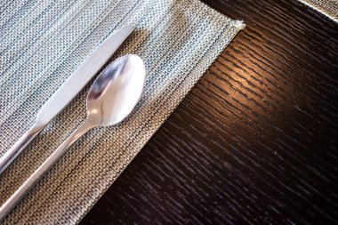 Boş yemek masasında kaşıklar ve çatallar servis edilmeyi bekliyor.