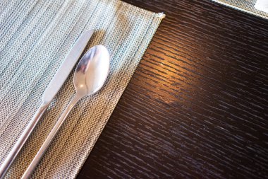 Boş yemek masasında kaşıklar ve çatallar servis edilmeyi bekliyor.