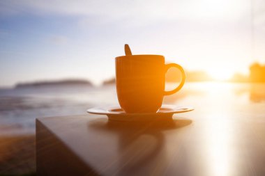 Sıcak bir sabah denizinde bir fincan kahve..