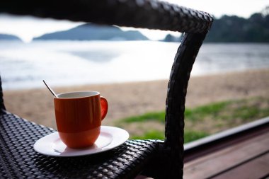 Sıcak bir sabah denizinde bir fincan kahve..