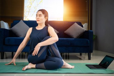 Asyalı kadın evde fiziksel egzersiz yapıyor.