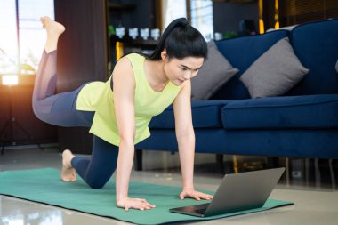 Asyalı bir kadın evde fiziksel egzersiz yapıyor. Sağlıklı bir kadın.