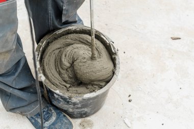 Genç erkek tuğla ustası beton yoğuruyor, havalanan beton bloklar döşemek için, inşaat alanında bir mikser kullanarak. Metin için boş alan. Boşluğu kopyala