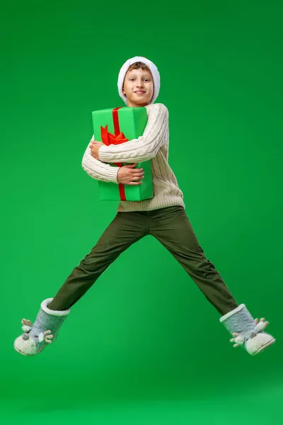 Счастливый Улыбающийся Мальчик Подарочной Коробкой Бантиком Руках Красной Шляпой Санты — стоковое фото
