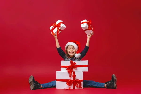 Счастливого Рождества Счастливая Маленькая Девочка Красной Шляпе Подарками Руках Красном — стоковое фото