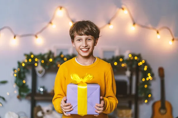 Boldog Karácsonyt Egy Vidám Fiú Sárga Pulóverben Ajándékot Tart Háttérben — Stock Fotó