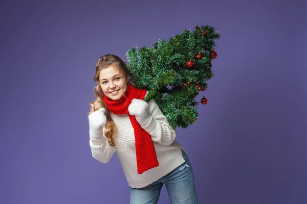 快乐的少女 头戴针织毛衣 头戴红围巾 肩上挂着红色圣诞彩球 走在紫色的背景上 动态图像 — 图库照片