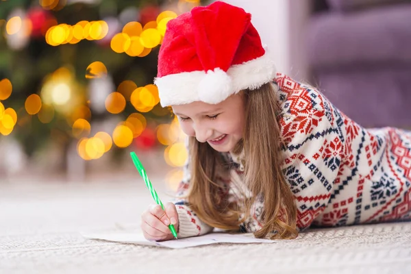 Small Child Santa Hat New Year Pajamas Lying Floor Writes — Stock Photo, Image