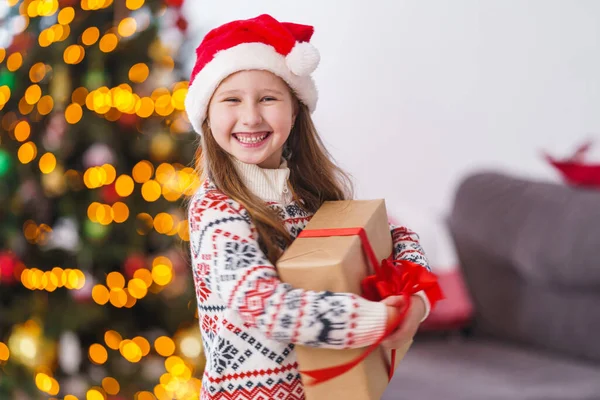 Милая Веселая Маленькая Девочка Пижаме Рождественская Шляпа Коробкой Завязанной Красной — стоковое фото