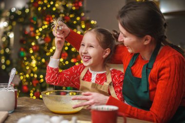 Mutlu noeller. Kızım annemin yemek yapmasına yardım eder. Aile yemekleri şenlikli yemekler. Anne ve kızı Noel kurabiyesi yapıyorlar. İyi tatiller. Akşam vakti, mutlu aile mutfakta..