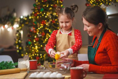 Mutlu noeller. Kızım annemin yemek yapmasına yardım eder. Aile yemekleri şenlikli yemekler. Anne ve kızı Noel kurabiyesi yapıyorlar. İyi tatiller. Akşam vakti, mutlu aile mutfakta..