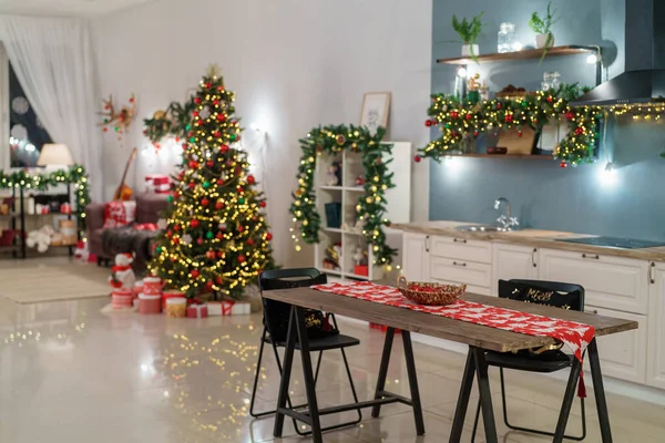 圣诞家居装饰有圣诞树和节日灯饰 背景厨房装饰节日 圣诞节和新年室内模糊的背景 许多在黑暗中发光的灯 图库照片