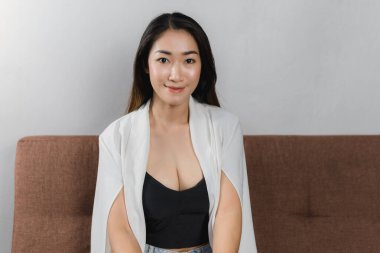 Evdeki kanepede oturan seksi Asyalı kadınlar.