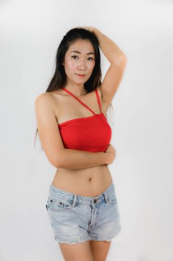 Seksi Asyalı kadın, beyaz arka planda tek kemerli kırmızı elbise..