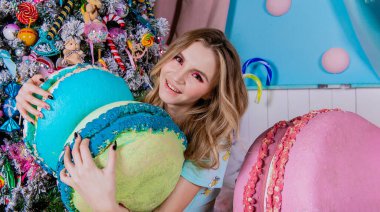 Beyaz güzel kız noel ağacı kurabiye oyuncaklarıyla oynar pijama yapar, seksi gülümser, pembe hediyeler verir