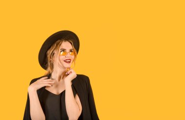 Sarı arka planda poz veren genç kız komik kahverengi elbiseler sarı gözlükler yer minimalistiği kopyalıyor