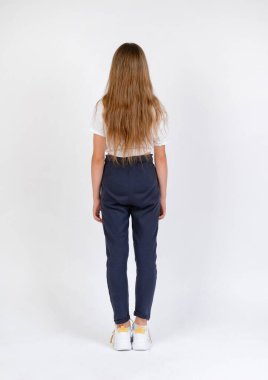 Mavi pantolonlu ve beyaz tişörtlü genç kız beyaz arka plana bak.