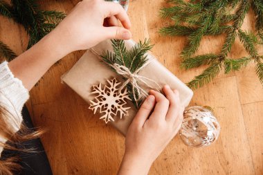 Hediye paketleyen eller noel ağacını dallandırır parlak basit arka plan minimalist tatiller