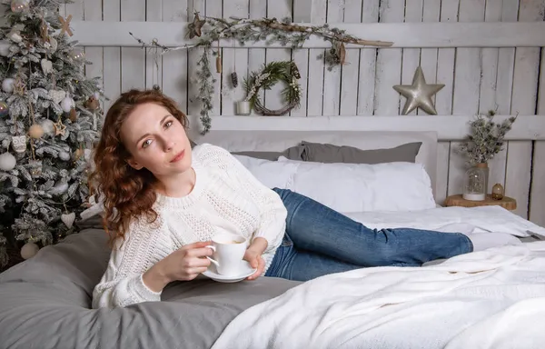 Beautiful Caucasian Girl White Sweater Blue Jeans Lying Bed Cup — Stock Photo, Image