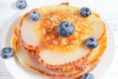 Böğürtlenli krepler açık arkaplanda bir tabakta, üst manzara