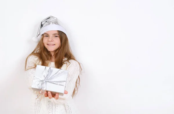 Młoda Dziewczyna Białym Swetrze Srebrnym Kapeluszu Santa Posiada Obecny Boże — Zdjęcie stockowe