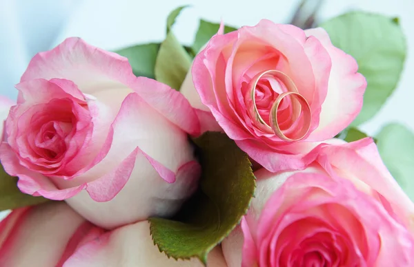 白色粉红玫瑰 有两个金戒指 简单的垂直绿叶浅色背景 — 图库照片