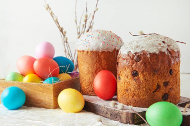 Renkli yumurtaları ve söğüt dalları olan Paskalya pastaları parlak bahar bayramları için yatay görünüyor.