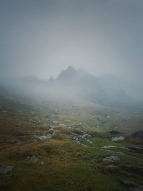 Yoğun siste transfagarasan dağ zirvesi görülüyor. Dağlarda yağmurlu bir sahne, siste yürüyüş.