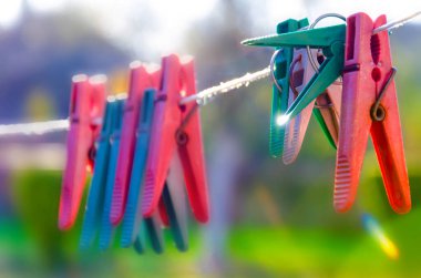 Bahçedeki ipte asılı mandallar, yaz günü çamaşır ipinde renkli plastik askılar..