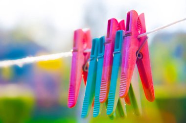 Bahçedeki ipte asılı mandallar, yaz günü çamaşır ipinde renkli plastik askılar..