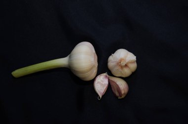 Siyah arka planda sarımsaklı karanfil ve sarımsak. sarımsak ve karanfil. Genç sarımsak yakın plan