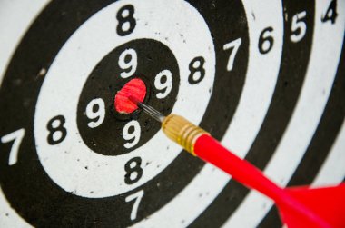 playing darts, darts in the center of the board. Red dart arrow on center of dartboard. Success, goals and objectives concept