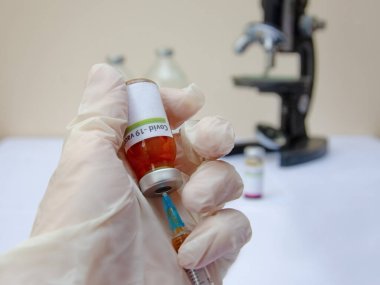 Laboratuvarda bir doktor ya da bilim adamı sıvı aşılarla dolu bir şırınga tutuyor. Coronavirus covid-19 ile savaşma konsepti,