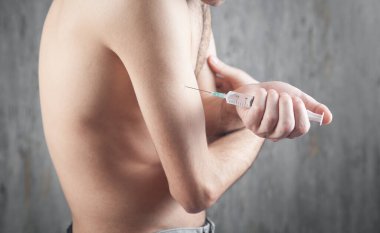 Şırınga tutan adam. Enjeksiyon yapılıyor