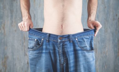 Büyük beden kot giyen bir adam. Kilo kaybı