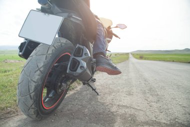 Motosiklet sürücüsü asfalt yolda tek başına gidiyor..