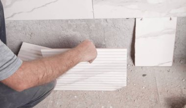 İşçi duvara fayans yerleştiriyor. 