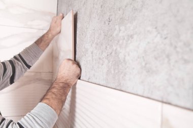 İşçi duvara fayans yerleştiriyor. 