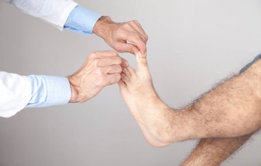 Kafkas doktoru hasta ayak parmaklarını muayene ediyor..