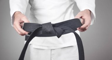 Beyaz adam siyah kuşağını tutuyor.. 