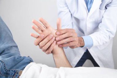 Kafkasyalı doktor hasta eline masaj yapıyor..