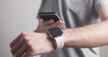 Akıllı saat ve akıllı telefon kullanan bir adam. Yaşam tarzı. Teknoloji