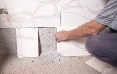 İşçi duvara fayans yerleştiriyor. 