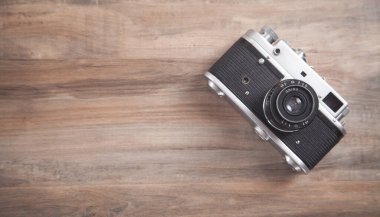 Ahşap arka planda eski bir retro kamera.