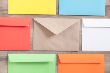 Ahşap arkaplanda renkli posta zarfları.